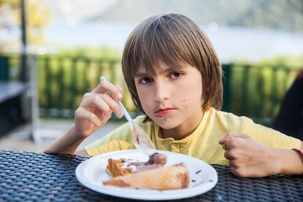 夏のテラスのカフェでアイスクリームを食べる少年 — ストック写真