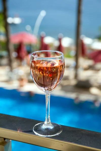 glass of rose wine with sea and pool view