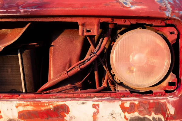 Parte do rosto e farol de um carro vermelho desmontado — Fotografia de Stock