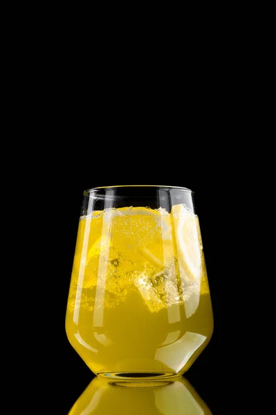 Limonade rafraîchissante avec tranches de citron et glaçons sur fond noir — Photo