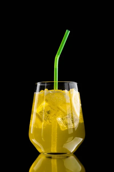 Osvěžující limonáda s citronovými plátky a kostkami ledu na černém pozadí — Stock fotografie