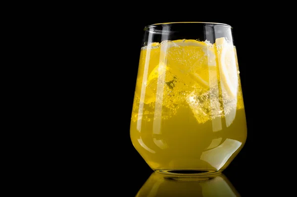 Refreshing lemonade with lemon slices and ice cubes on black background — Stock Photo, Image