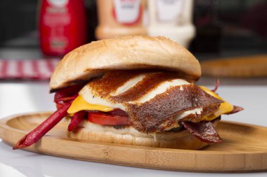 Burger kızarmış yumurta, peynir, sebze ve sosis ahşap tahta üzerinde Kapat