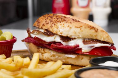 Burger kızarmış yumurta, sebze ve patates kızartması ve soslar eşliğinde sosis ile yakın çekim 