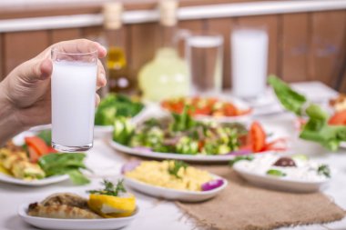 Cam içecek ile farklı yemekler ile masa üzerinde tutan adam