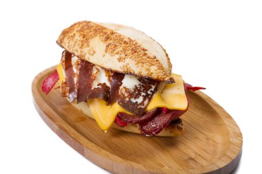 Burger kızarmış yumurta, peynir, sebze ve sosis ahşap tahta üzerinde Kapat