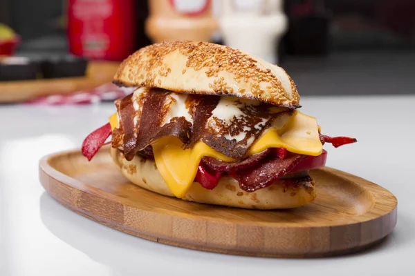 Burger kızarmış yumurta, peynir, sebze ve sosis ahşap tahta üzerinde Kapat