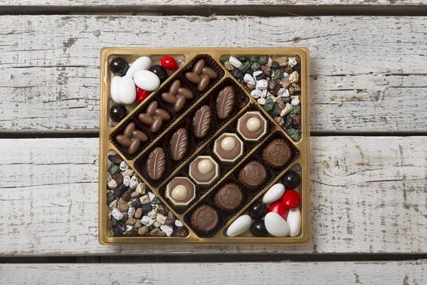 不同的巧克力糖果包装上的木质背景 — 图库照片