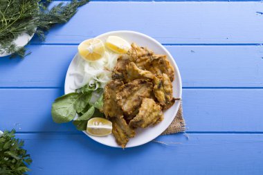 Yeşil ve mavi ahşap masa, deniz ürünleri üzerinde limon ile kızarmış balık