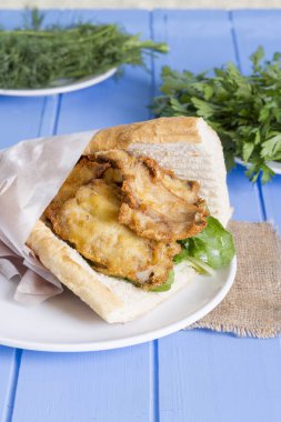 lezzetli kızarmış balık sandviç üzerinde mavi ahşap masa üzerinde Kapat 