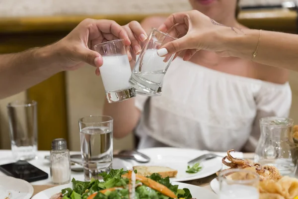 Üç arkadaş restoranda Türk geleneksel rakı içki içme