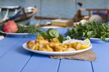 Kızarmış balık dilimleri ile yeşil ve mavi ahşap masa açık havada limon