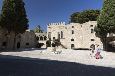 Rhodes, Yunanistan - 26 Ağustos 2017: turist Grand Master Şövalyeleri oldu hangi mimarisi inşa Knights döneminin şehrin altındaki XVI yüzyılda sokak yürüyüş. Kastello Ortaçağ kalesidir.
