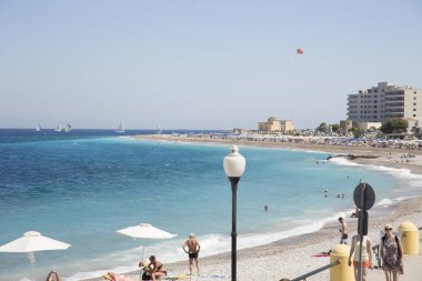 Rhodes, Yunanistan - 26 Ağustos 2017: Akti Miaouli plaj kısa yürüme mesafesinde Rodos'un şehir yer alır ve gri çakıl ve kum oluşur. Bu değil bir özellikle geniş bir plaj kum şerit.