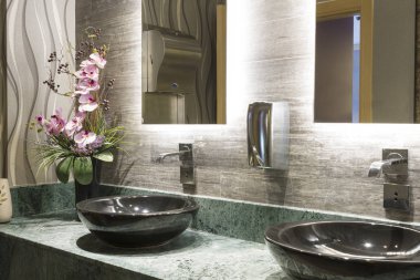 Yeşil özel tasarım mermer Counter, siyah Top Counter lavabo, güzel pembe çiçek, krom musluk, metal sabun dispenseri ve bej dokulu duvar karoları, ofis binası içinde ticari ortak banyo