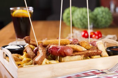 Tabloda kızarmış taze bira tabak patates kızartması, tavuk Nuggets, peynir parmak, soğan halkaları, sosis, acı sos ile deef