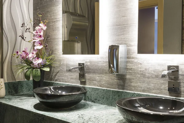 Green Special Design Marble Counter, Black Top Counter Washbasin, beautiful pink flower, chrome tap, metal soap dispenser and beige Textured Wall Tiles at Commercial Public Bathroom in Office Building