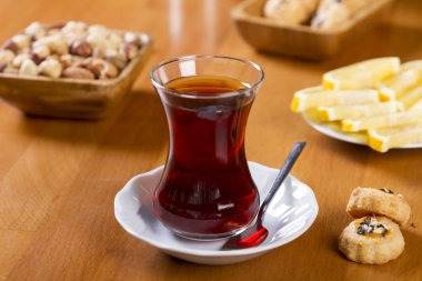 Türkçe ve Arapça geleneksel ramazan siyah çay beyaz tabak, metal kaşık, limon dilimi, kurabiye, bisküvi ve ahşap masa arka plan üzerinde fındık ile özel tasarım cam