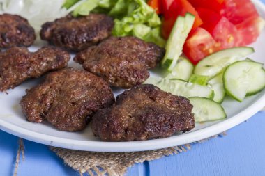 Yeşiller ve köfte ahşap arka plan üzerinde sebze salatası, yakın çekim