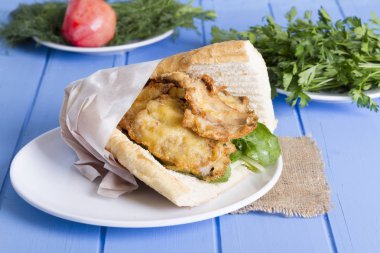 lezzetli kızarmış balık sandviç üzerinde mavi ahşap masa üzerinde Kapat 