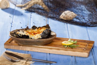 Lezzetli bütün sakat plaka bambu kesme tahtası üzerinde Zeytinyağlı patlıcan veya karniyarik dolması 