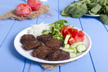 Yeşiller ve köfte ahşap arka plan üzerinde sebze salatası, yakın çekim