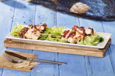 sopa üzerinde Izgara ahtapot adet yeşil salata yaprakları ile görev yaptı.