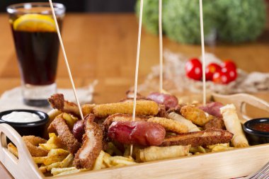 Tabloda kızarmış taze bira tabak patates kızartması, tavuk Nuggets, peynir parmak, soğan halkaları, sosis, acı sos ile deef