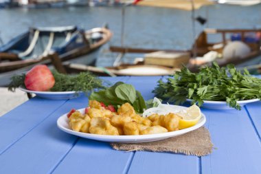 Kızarmış balık dilimleri ile yeşil ve mavi ahşap masa açık havada limon