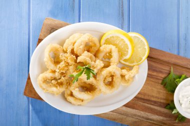 Zeytinyağı ile beyaz tabak lezzetli deniz ürünleri altın kızarmış gevrek kalamar halkaları 