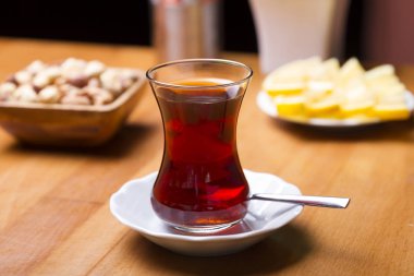 Türkçe ve Arapça geleneksel ramazan siyah çay beyaz tabak, metal kaşık, limon dilimi, kurabiye, bisküvi ve ahşap masa arka plan üzerinde fındık ile özel tasarım cam