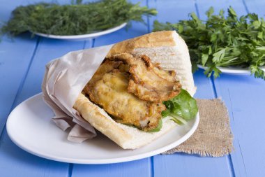 lezzetli kızarmış balık sandviç üzerinde mavi ahşap masa üzerinde Kapat 