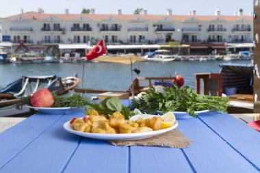 Kızarmış balık dilimleri ile yeşil ve mavi ahşap masa açık havada limon