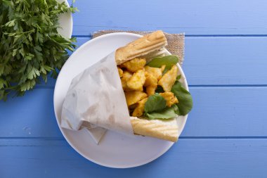 kızarmış balık dilimleri ve yeşillik ile lezzetli sandviç üstten görünüm mavi ahşap tablo 