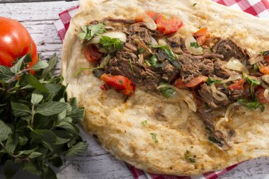 Türkçe ve Arapça geleneksel Delicious ramazan kuzu sığır eti kebabı soğan, domates, maydanoz ve rustik beyaz ahşap zemin üzerinde özel sosu ile flatbreadserving üzerinde.