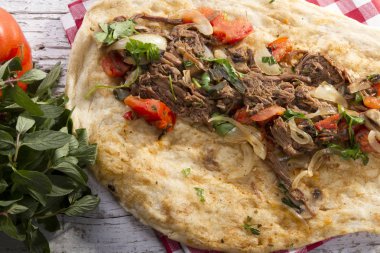 Türkçe ve Arapça geleneksel Delicious ramazan kuzu sığır eti kebabı soğan, domates, maydanoz ve rustik beyaz ahşap zemin üzerinde özel sosu ile flatbreadserving üzerinde.