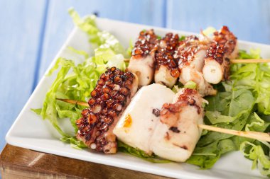 sopa üzerinde Izgara ahtapot adet yeşil salata yaprakları ile görev yaptı.