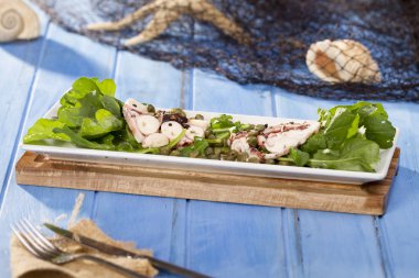 Lezzetli deniz ürünleri ahtapot roka ile beyaz plaka