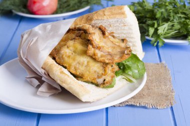 lezzetli kızarmış balık sandviç üzerinde mavi ahşap masa üzerinde Kapat 