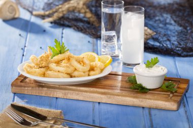 Zeytinyağı ile beyaz tabak lezzetli deniz ürünleri altın kızarmış gevrek kalamar halkaları 