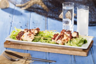 sopa üzerinde Izgara ahtapot adet yeşil salata yaprakları ile görev yaptı.