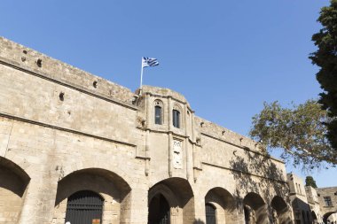 Rhodes, Yunanistan - 26 Ağustos 2017: turist Grand Master Şövalyeleri oldu hangi mimarisi inşa Knights döneminin şehrin altındaki XVI yüzyılda sokak yürüyüş. Kastello Ortaçağ kalesidir.
