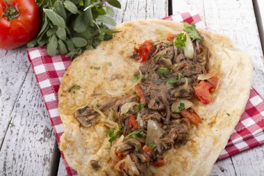 Türkçe ve Arapça geleneksel Delicious ramazan kuzu sığır eti kebabı soğan, domates, maydanoz ve rustik beyaz ahşap zemin üzerinde özel sosu ile flatbreadserving üzerinde.