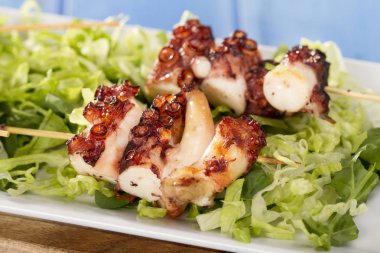 sopa üzerinde Izgara ahtapot adet yeşil salata yaprakları ile görev yaptı.