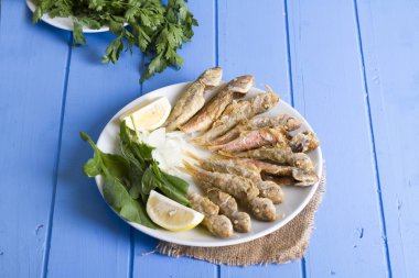 yeşil ve mavi ahşap masa, deniz ürünleri üzerinde limon ile kızarmış balık yakın çekim