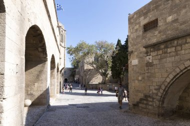 Rhodes, Yunanistan - 26 Ağustos 2017: turist Grand Master Şövalyeleri oldu hangi mimarisi inşa Knights döneminin şehrin altındaki XVI yüzyılda sokak yürüyüş. Kastello Ortaçağ kalesidir. 