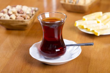 Türkçe ve Arapça geleneksel ramazan siyah çay beyaz tabak, metal kaşık, limon dilimi, kurabiye, bisküvi ve ahşap masa arka plan üzerinde fındık ile özel tasarım cam