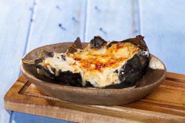 Lezzetli bütün sakat plaka bambu kesme tahtası üzerinde Zeytinyağlı patlıcan veya karniyarik dolması 