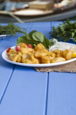 Kızarmış balık dilimleri ile yeşil ve mavi ahşap masa açık havada limon