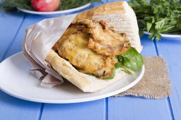 lezzetli kızarmış balık sandviç üzerinde mavi ahşap masa üzerinde Kapat 